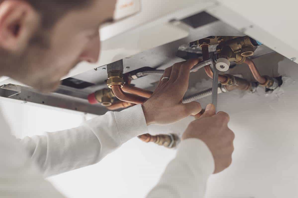 professional emergency plumber checking a boiler system in London