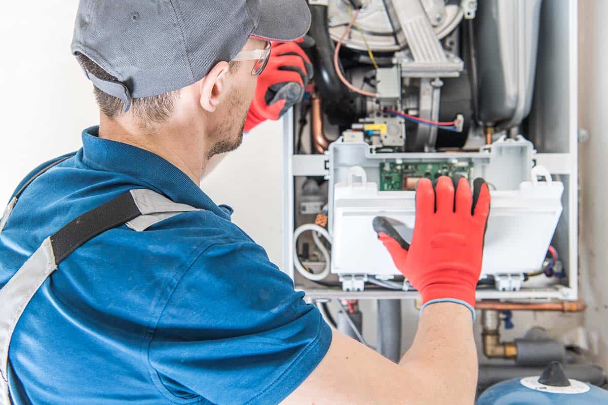 gas engineer fixing central heating system in London