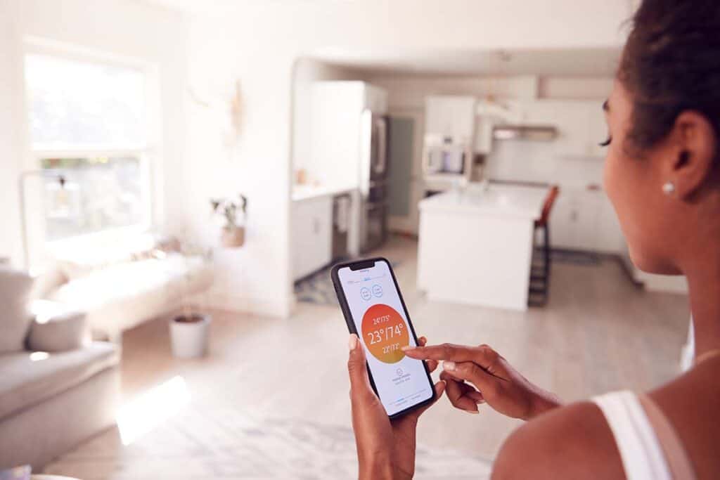 woman controlling central heating installation via phone app